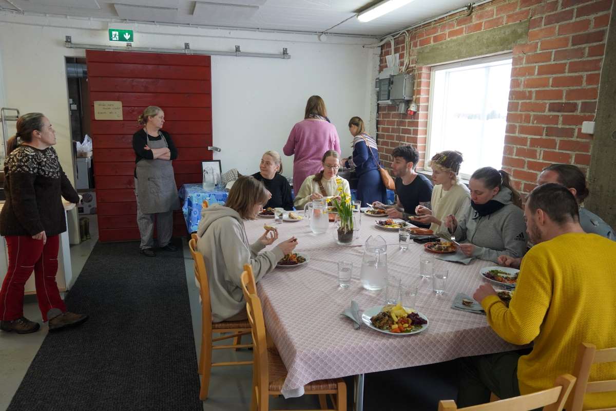 AgriCulinary-opiskelijat ruokailemassa pöydän ääressä Haltijan tilalla.